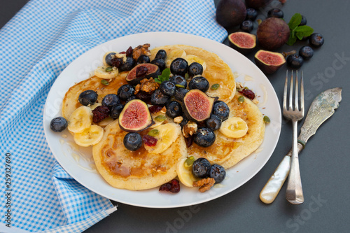 Pancakes with blueberries, mint, fruits and honey for breakfast - homemade healthy food. Breakfast idea.