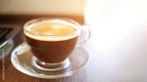 Cup of fresh brewed coffee near the coffee machine