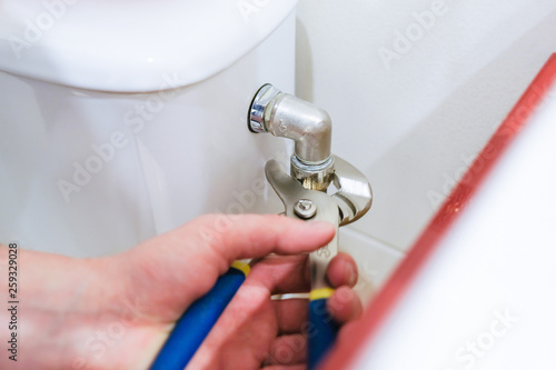 Sanitary worker performs repair of toilet bowl