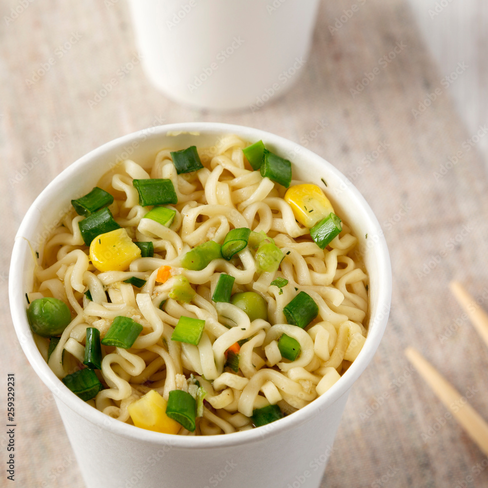 Instant ramen noodles in paper cups, low angle view. Close-up. Instant ramen noodles in paper cups, low angle view. Close-up.