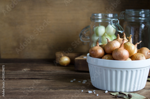 homemade pickled onions in a glass jar in a rustic style. copy space.