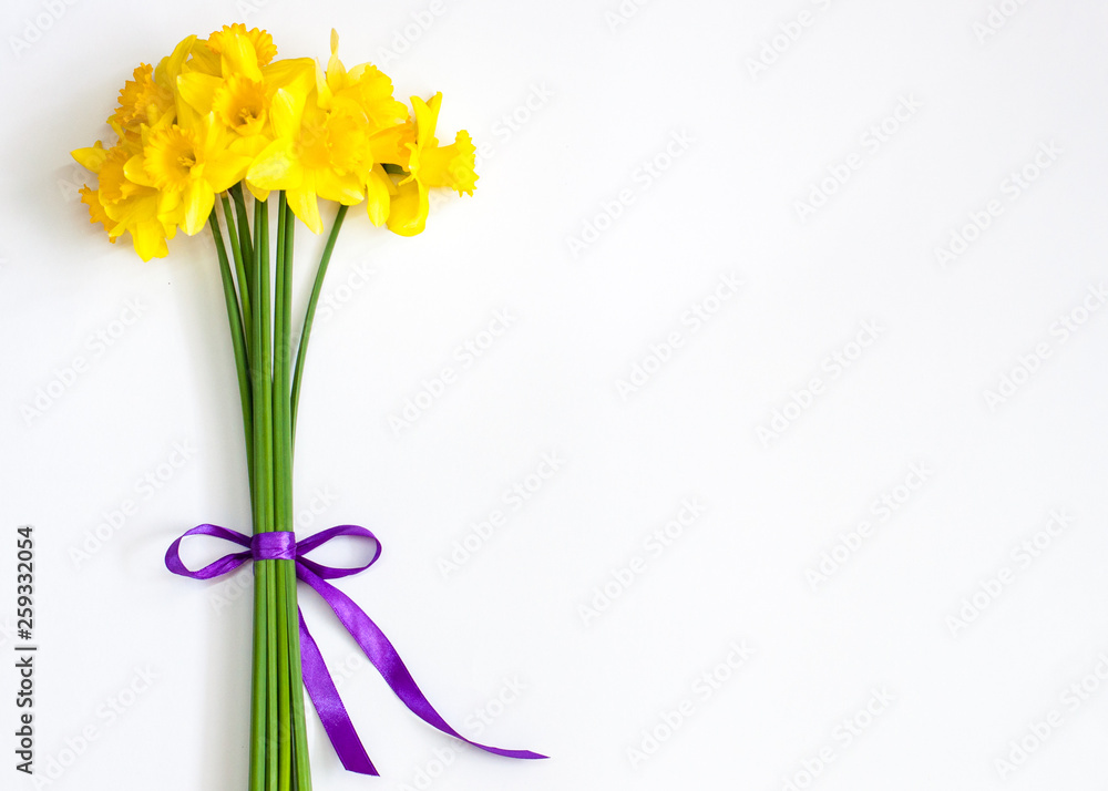 Bright bouquet with purple ribbon. Spring flowers. Narcissuses.