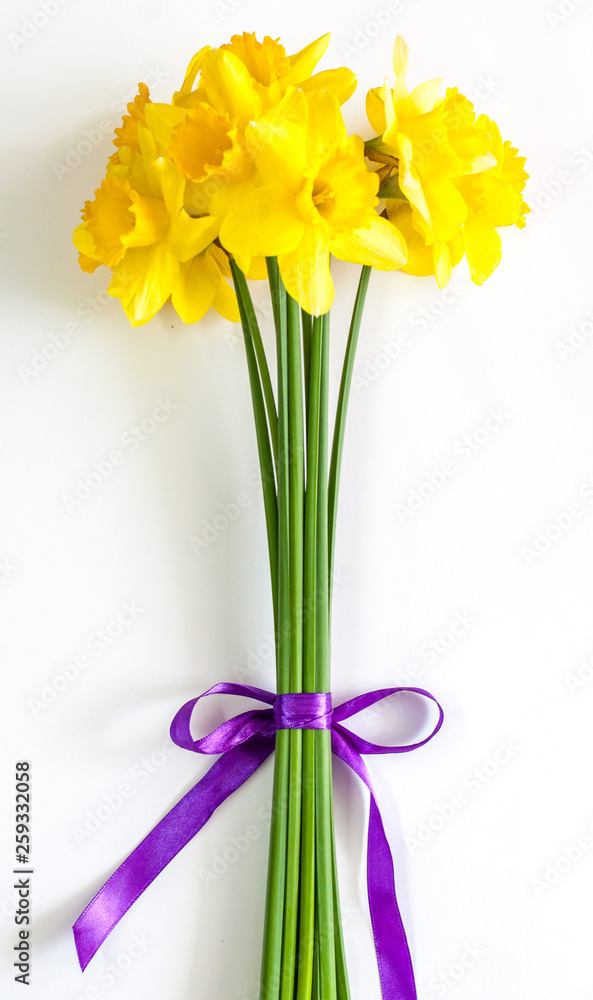 Spring flowers with purple ribbon. Easter. Yellow daffodil.