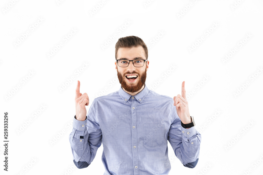 Naklejka premium Cheerful bearded elegant man in eyeglasses pointing up