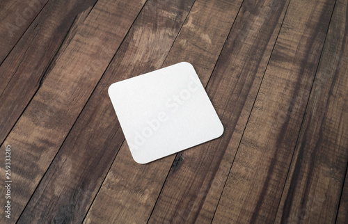 Blank beer coaster on wood table background.