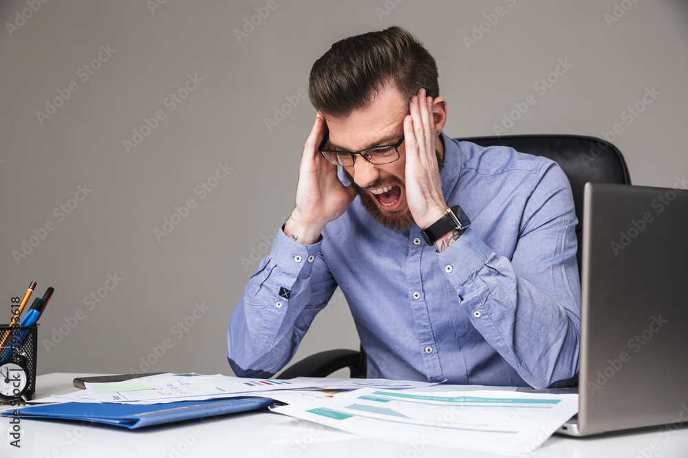Tired screaming bearded elegant man in eyeglasses holding his head Tired screaming bearded elegant man in eyeglasses holding his head