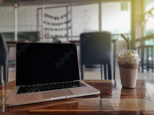 Laptop with coffee on table on cafe background