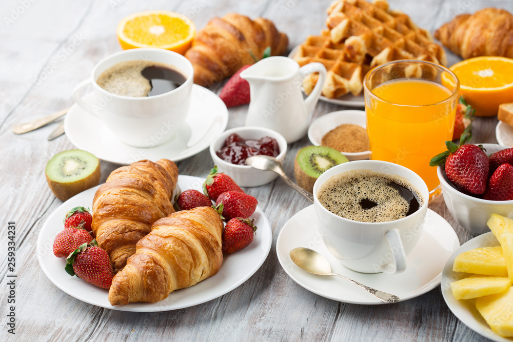 Continental breakfast table with coffee, orange juice, croissants Continental breakfast table with coffee, orange juice, croissants
