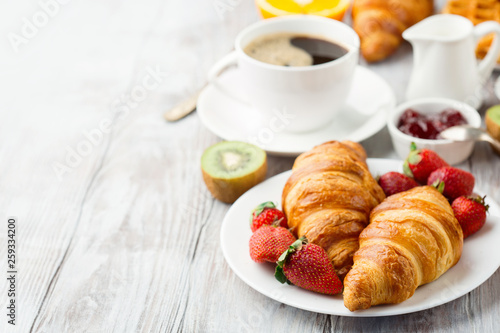 Continental breakfast table with coffee, orange juice, croissants
