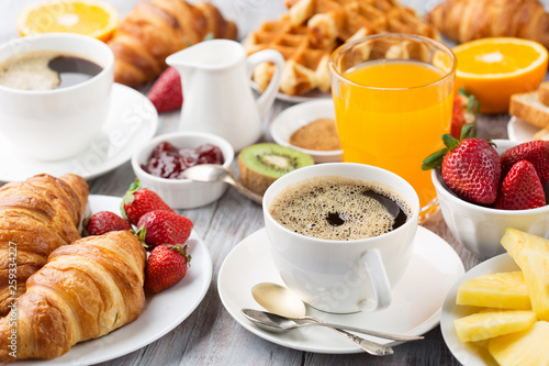 Fototapeta Continental breakfast table with coffee, orange juice, croissants