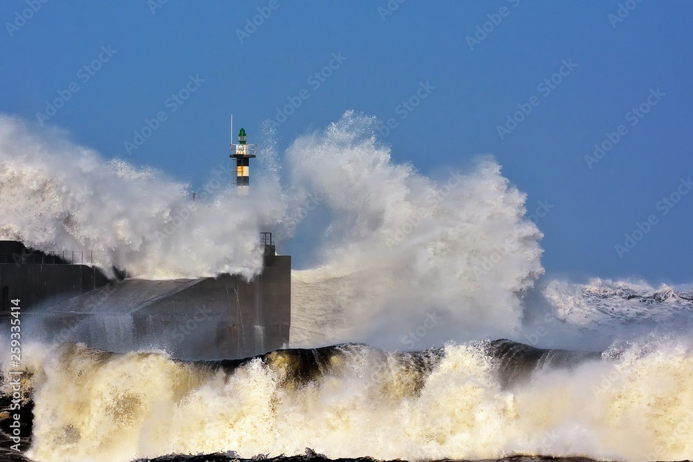 Fototapeta Stormy wave over lighthouse of San Esteban de Pravia.