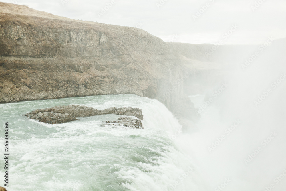  View of a large waterfall in Iceland. June summer day near the raging mountain river and waterfall