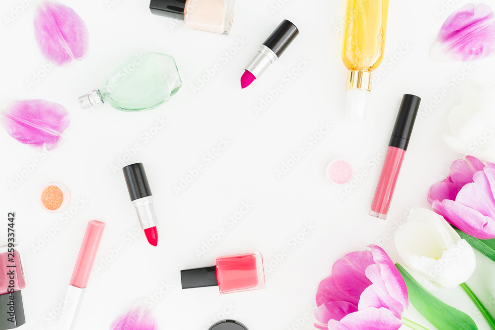Frame made of tulips flowers and cosmetics, lipstick, nail polish on white background. Top view. Flat lay Frame made of tulips flowers and cosmetics, lipstick, nail polish on white background. Top view. Flat lay