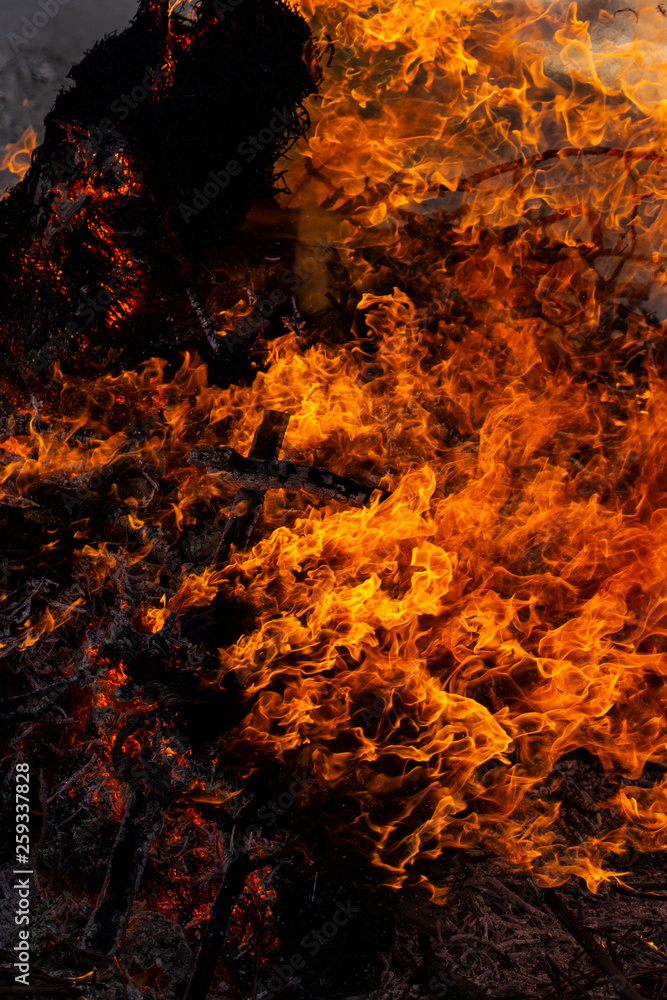 Flaming fire. Burning tree branches. Pagan rite dedicated to the arrival of spring. Big bonfire on Shrovetide. Flaming fire. Burning tree branches. Pagan rite dedicated to the arrival of spring. Big bonfire on Shrovetide.