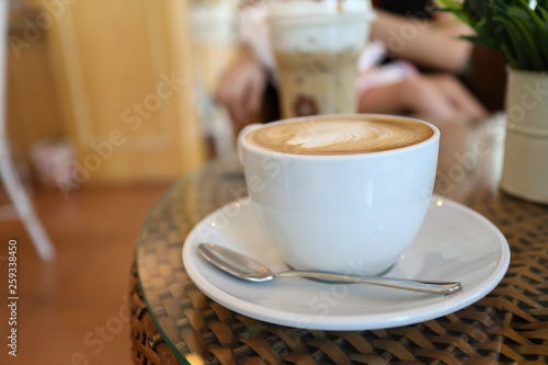 white cup of hot coffee drink put on table in cafe restaurant