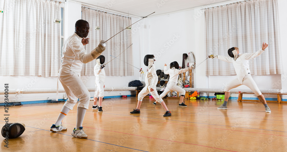 adults and children athletes at fencing workout