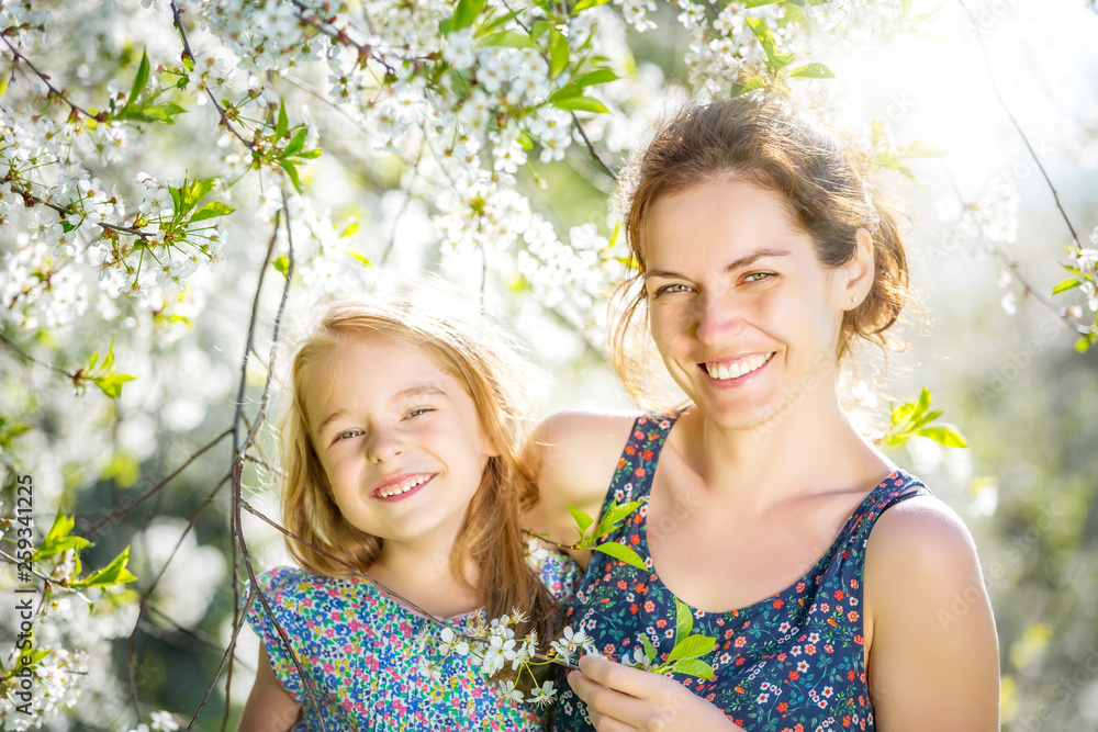 Fototapeta premium Mother and daughter in spring cherry blossom park
