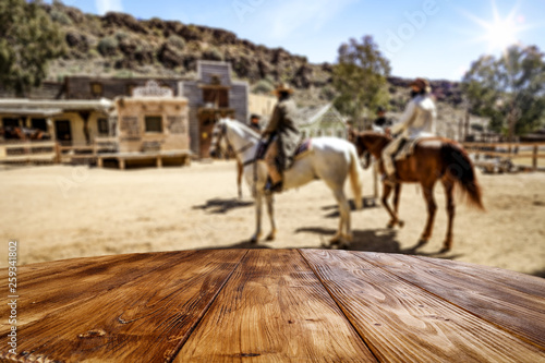 Wooden old table of free space for your product. Blurred background of Wild West city in America. 