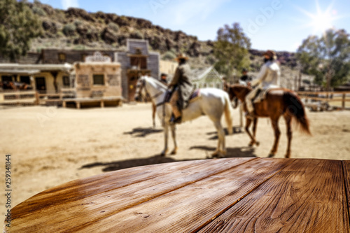 Wooden old table of free space for your product. Blurred background of Wild West city in America. 