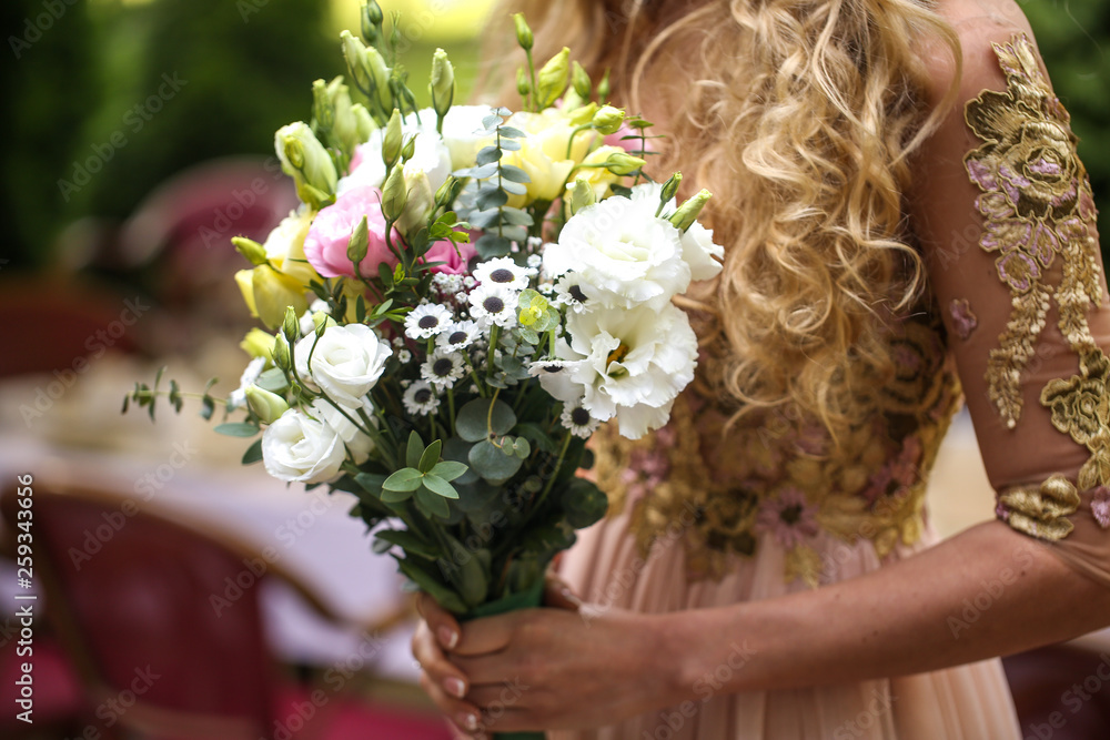 Bride posing in the park with her wedding bouquet