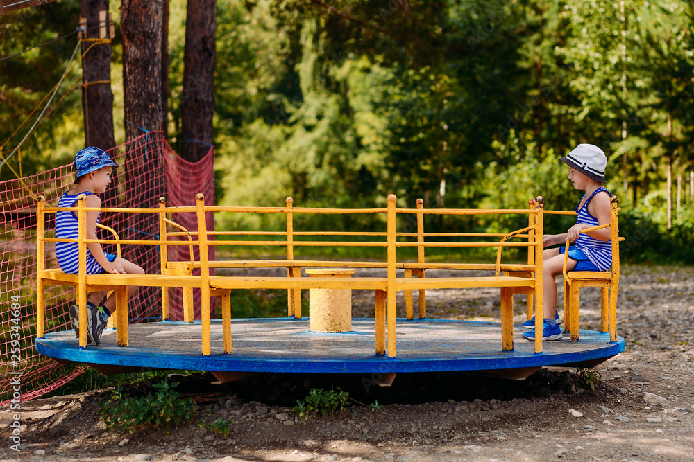preschool children in summer hats ride on the big carousel in the Park in the summer preschool children in summer hats ride on the big carousel in the Park in the summer