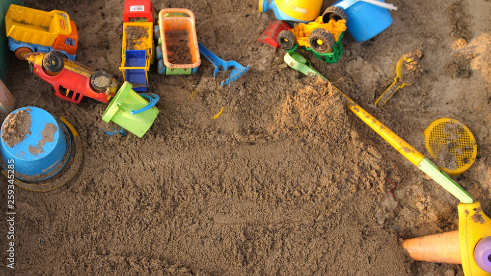 Top of view of a sandbox with toys on playground in sunny day Top of view of a sandbox with toys on playground in sunny day