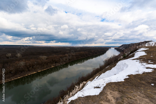 Fototapeta Naklejka Na Ścianę i Meble -  wide river in spring. snow on the river Bank. overcast sky