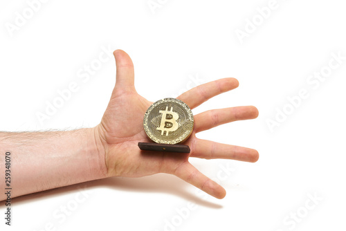 Bitcoin coin made of wood in male hands on white background