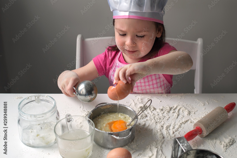 baby making buns. The child plays the cook. The child cooks pancakes from flour and eggs baby making buns. The child plays the cook. The child cooks pancakes from flour and eggs