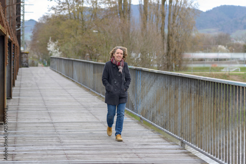 Woman crossing a bridge walking towards the camera