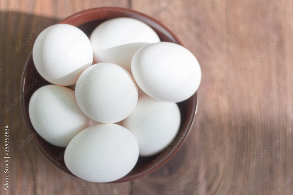white chicken eggs in bowl on wooden background white chicken eggs in bowl on wooden background