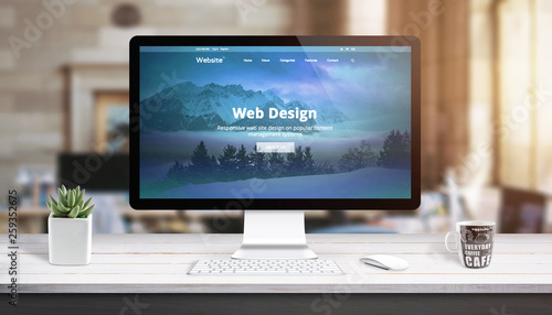 Modern web design page on computer display. Concept of web design studio work desk. photo