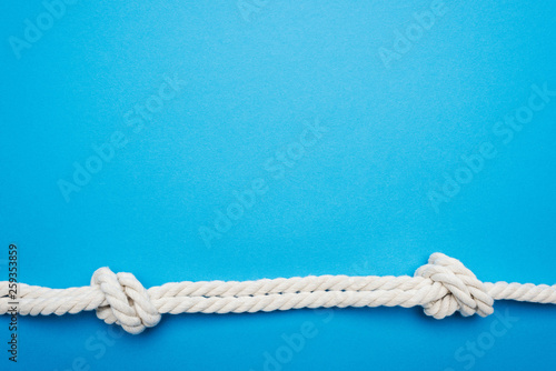 white long twisted ropes with sea knots isolated on blue