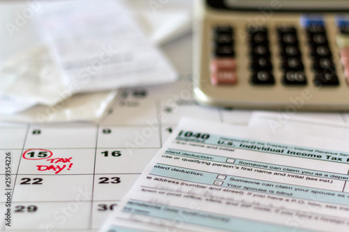 Desk with tax form, receipts, calculator and calendar. Financial Accounting Taxation Concept