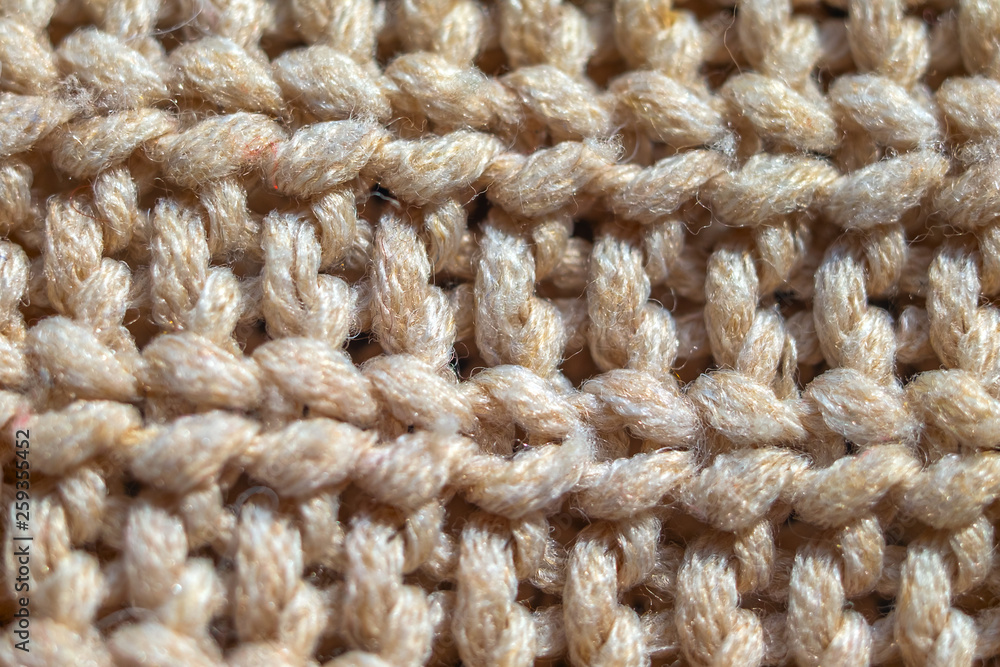 Close-up knit stitching beige close-up, handmade woolen fabric. Close-up knit stitching beige close-up, handmade woolen fabric.