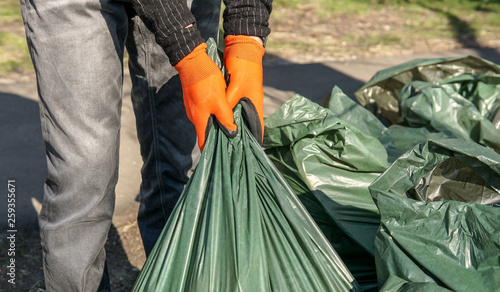 Hand man picking up trash cleaning in the street , volunteer concept