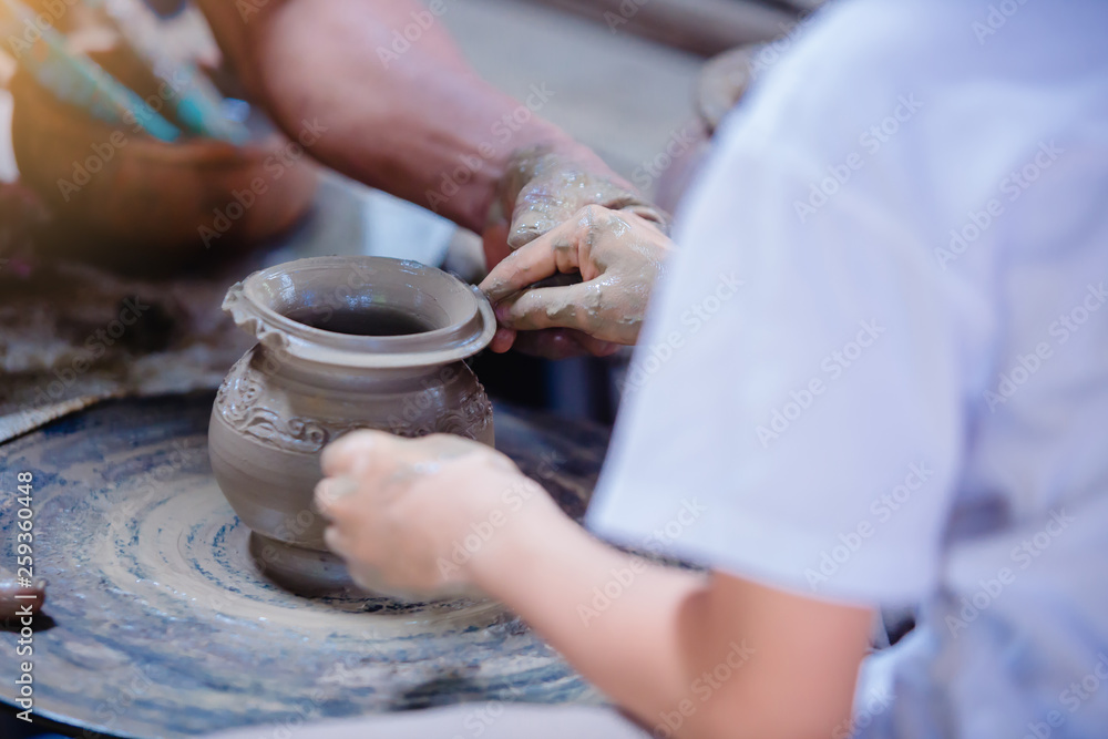 Making it together. close-up to hands of potter teacher and child Making it together. close-up to hands of potter teacher and child