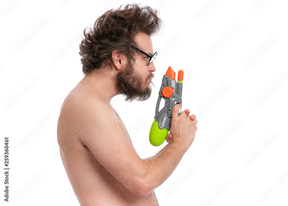 Crazy bearded Man with funny Haircut in eyeglasses, ready for fun at sunny beach. Happy and silly tourist, isolated on white background. Cheerful naked man holding Water Gun. Crazy bearded Man with funny Haircut in eyeglasses, ready for fun at sunny beach. Happy and silly tourist, isolated on white background. Cheerful naked man holding Water Gun.