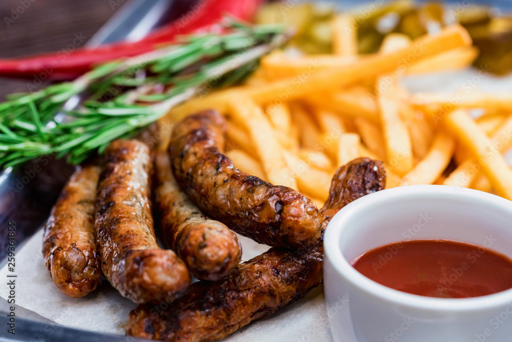 Close up meal with sausages, french fries, chili pepper and jalapeno