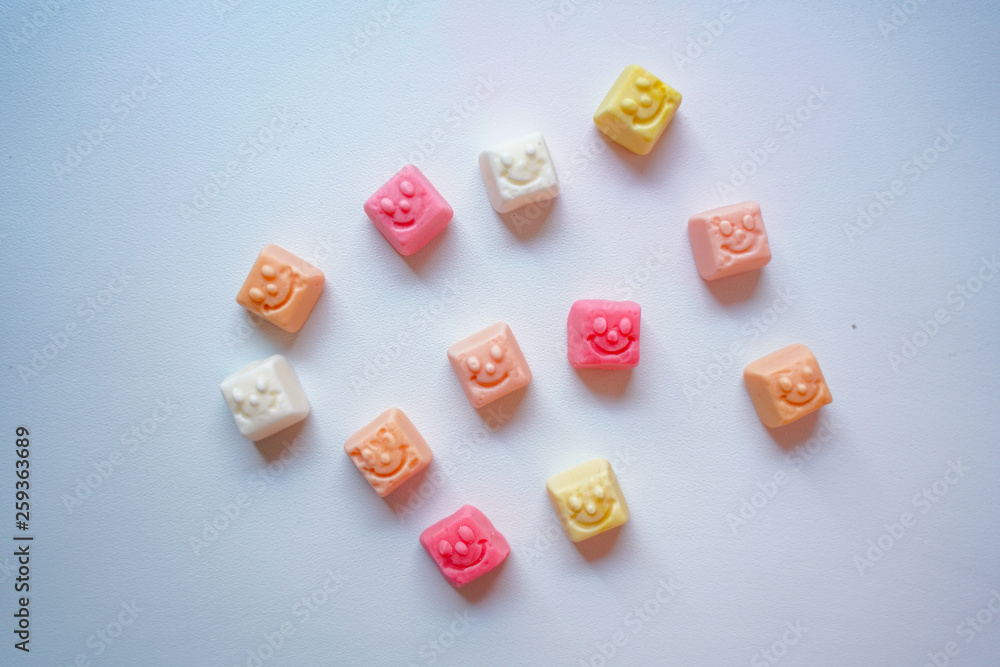 delicious square bright candy with smile on white background delicious square bright candy with smile on white background