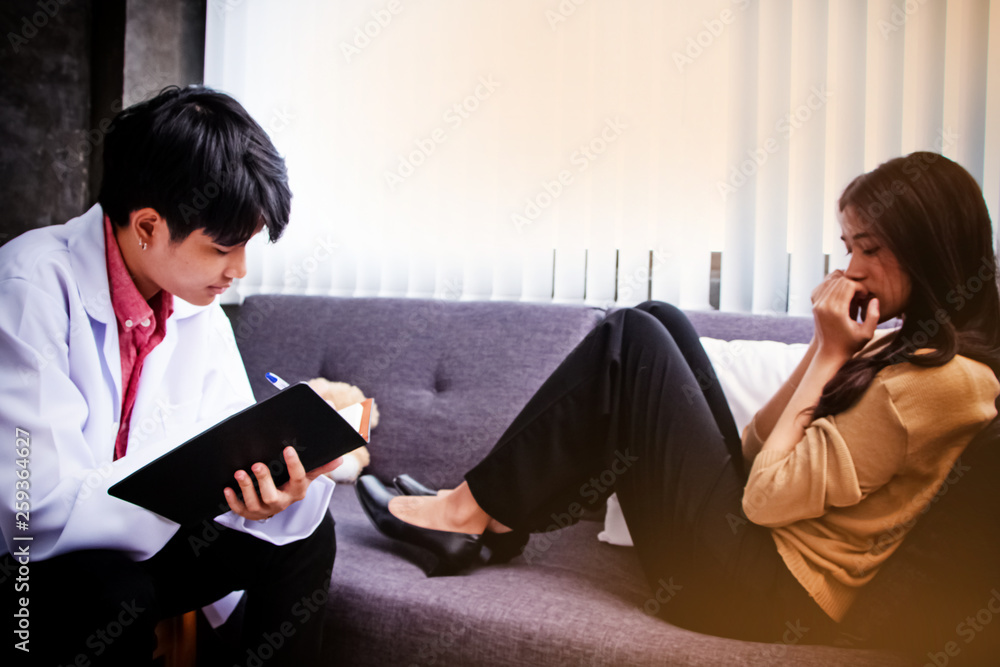 In selective focus of The psychiatrist talking with the stressed woman,consult for treatment plan,treat mental illness,blurry light aorund,vignette lens effect In selective focus of The psychiatrist talking with the stressed woman,consult for treatment plan,treat mental illness,blurry light aorund,vignette lens effect