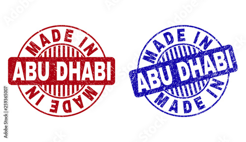 Grunge MADE IN ABU DHABI round stamp seals isolated on a white background. Round seals with distress texture in red and blue colors.