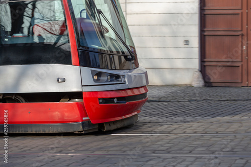 Red Passenger train locomotive cab rides on the street