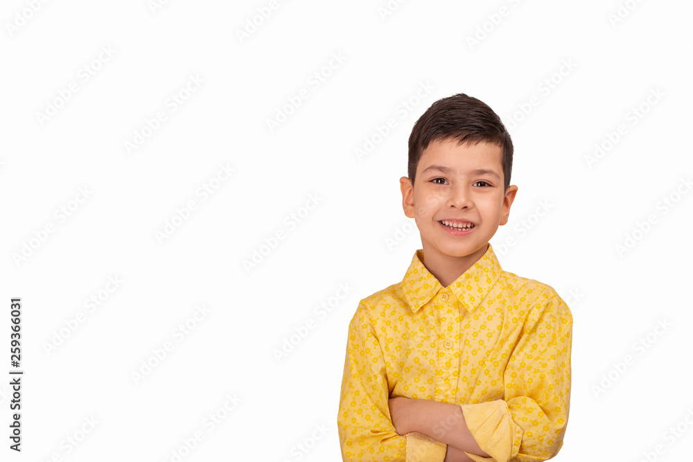 Portrait of smiling young boy wearing yellow shirt with arm crossed on white background with copy space in studio Portrait of smiling young boy wearing yellow shirt with arm crossed on white background with copy space in studio