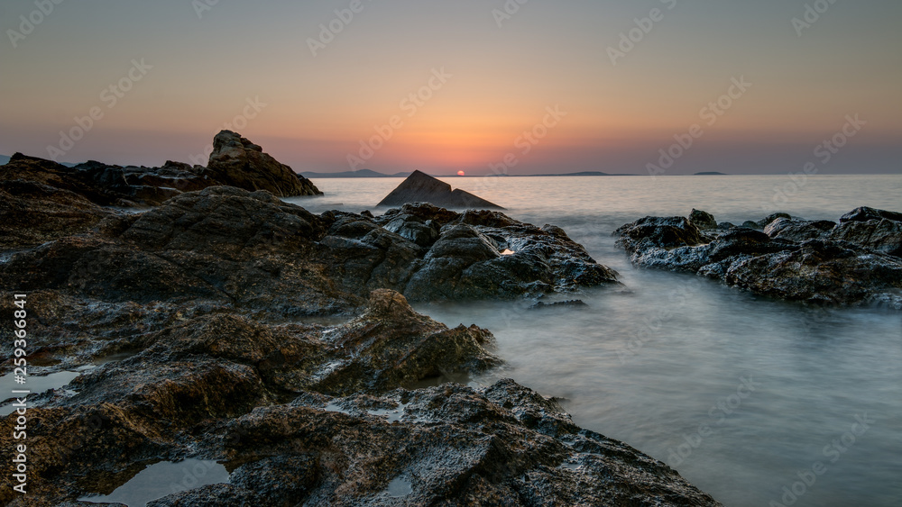 coucher de soleil sur des rocher au bord de la mer