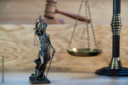 Themis , symbol of law and justice on wooden background