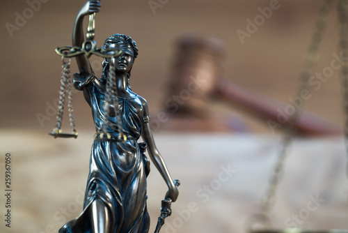 Themis , symbol of law and justice on wooden background © Aerial Mike