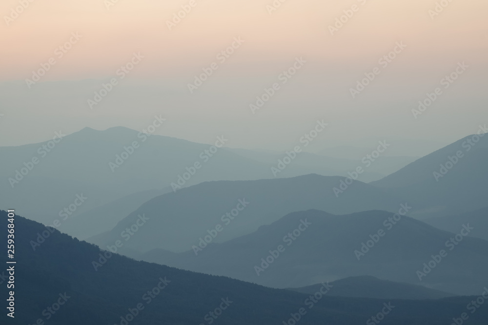 Beautiful Landscape of mountain layer in morning sun light and fog at Ukraine, Carpathians Borjava Ridge