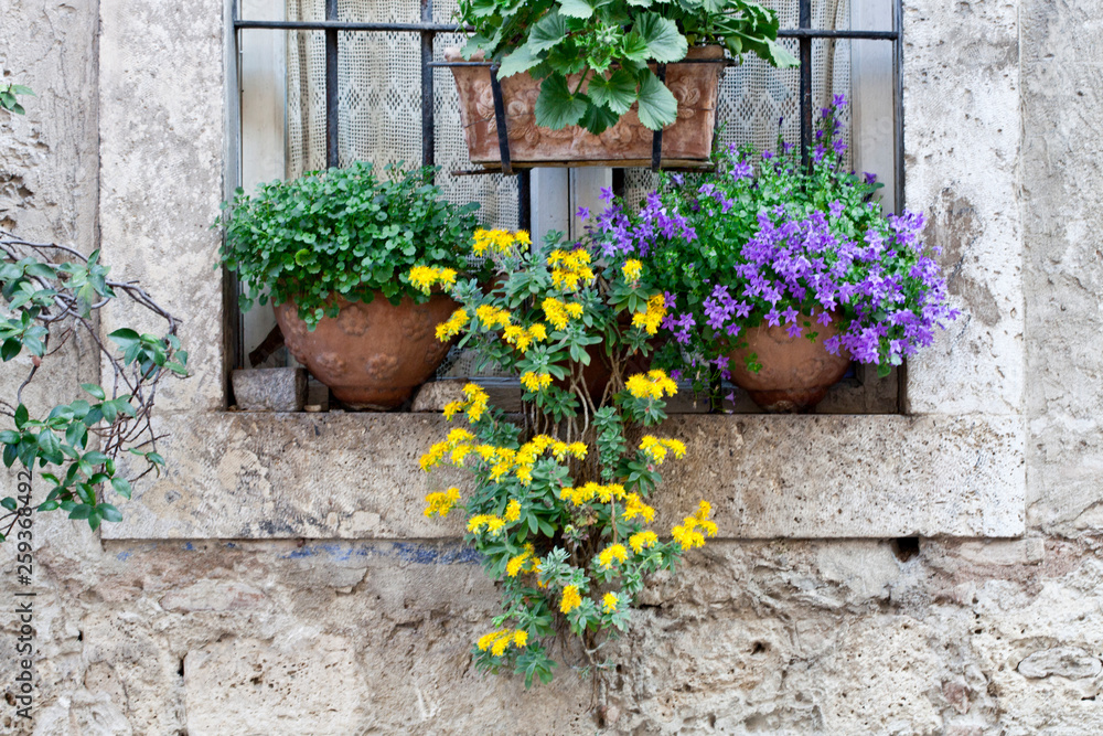 Italian window decorated with flowers.