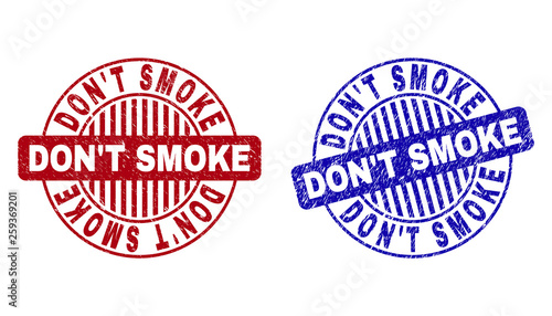 Grunge DON T SMOKE round stamp seals isolated on a white background. Round seals with grunge texture in red and blue colors.